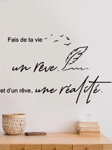 Detail of French quote wall decal with birds and feathers on a white wall