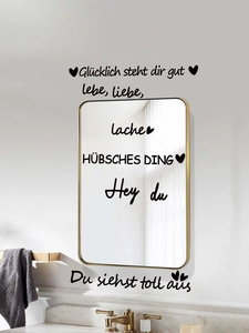 Close-up of black matte PVC wall decals with German quotes on bathroom mirror and wall