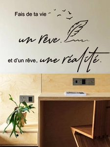 Detail of French quote wall decal with black feathers and birds on a white living room wall