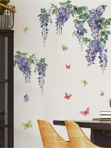 Détail de stickers muraux de glycines mauves et papillons sur un mur de salon blanc