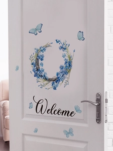 Dettaglio dell'adesivo per porta welcome floreale blu con farfalle su superficie bianca