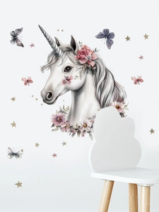 Detail of magical unicorn wall decal with pink floral crown and stars for nursery decor