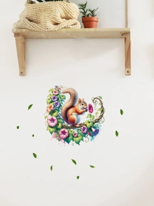 Detail of squirrel and morning glory wall decal on a white wall with a wooden shelf