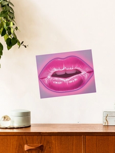 Detail showing neon pink lips art print on a white wall above a vintage wooden cabinet
