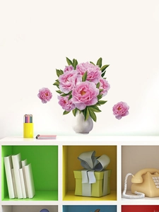 Détail du sticker mural vase de pivoines roses sur mur blanc au-dessus d'un meuble