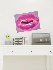 Close-up of pink neon lip wall sticker on a white room wall with desk decor