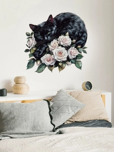 Detail of black cat and white roses wall decal applied on a bedroom wall above pillows