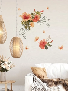 Détail de stickers muraux fleurs d'hibiscus orange et papillons dans un salon chaleureux