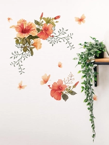 Détail des stickers muraux fleurs d'hibiscus orange et papillons dans un salon chaleureux