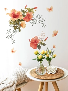 Détail de stickers muraux fleurs d'hibiscus orange et papillons dans un salon chaleureux