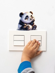 Close-up of a cute panda wall sticker being applied around a light switch panel