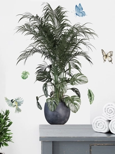 Detail showing tropical monstera leaves and blue butterfly wall stickers on a white wall