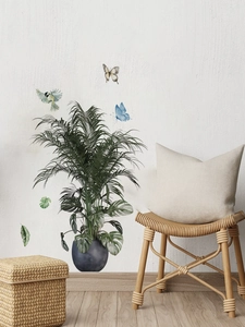 Detail of tropical palm and monstera leaf wall stickers with butterfly and bird accents