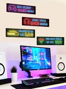 Close-up of four-piece neon gamer wall art set with vibrant slogans in a gaming room setup