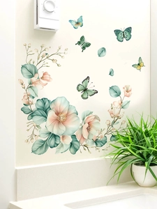 Close-up of green and pink floral wall stickers with butterflies in a home setting