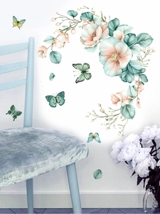 Detailed view of floral and butterfly wall decals on a minimalist white wall background