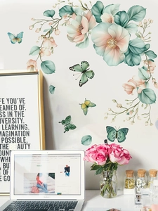 Detail of floral and butterfly PVC wall decals applied on a clean white living room wall