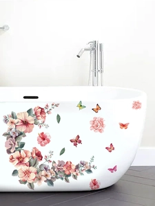 Detailed view of pink floral and butterfly wall stickers applied on a white bathtub side