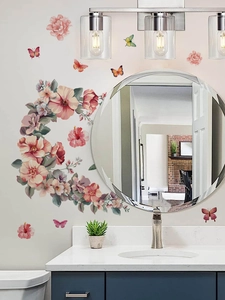 Detail of pink floral and butterfly wall decals applied around a round bathroom mirror
