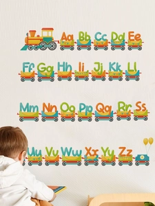 Detail of colorful alphabet cartoon train wall decals applied on a grey textured wall