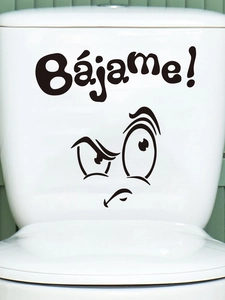 Detail of funny 'Bájame!' sticker applied on toilet tank with humorous cartoon face design