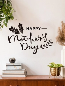 Détail d'un sticker mural noir HAPPY Mother's Day avec feuilles sur un mur blanc