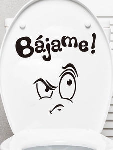 Close-up of funny cartoon face toilet lid sticker with Spanish text Bájame print