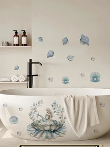 Detail showing blue mermaid and seashell wall stickers on a white bathtub in a bathroom