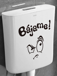Detail of funny cartoon expression toilet sticker with Bájame text on white tank
