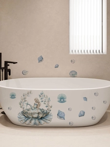 Watercolour mermaid and shell wall stickers applied on a white bathtub in a bright bathroom