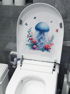 Detail view of jellyfish and floral toilet stickers on a white bathroom seat lid