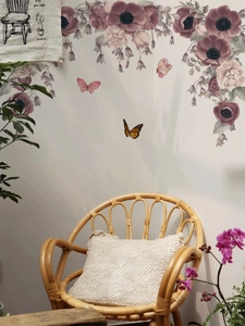 Dettaglio di adesivi murali con fiori viola e farfalle in un accogliente soggiorno relax