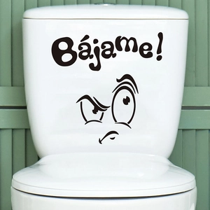 Funny cartoon face toilet sticker with Bajame text on white lid against green wall