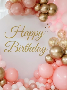 Detail of Happy Birthday gold lettering on a white round backdrop with party balloons