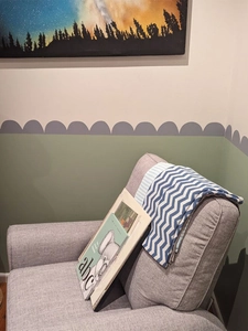 Dettaglio dell'adesivo murale ondulato grigio e verde in un soggiorno dal design moderno