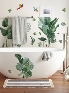 Détail de stickers muraux tropicaux avec feuilles de monstera et perroquets décoratifs