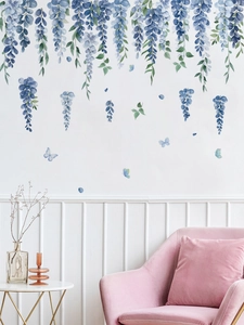 Detail of blue wisteria wall sticker and butterflies on white wall above a sofa