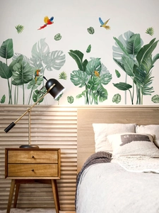 Détail de stickers muraux feuilles de monstera et perroquets colorés dans une chambre