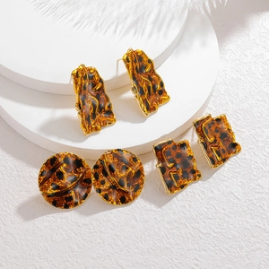 Détail d'un lot de trois paires de boucles d'oreilles géométriques léopard dorées