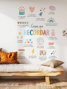 Detail of Spanish inspirational wall stickers with colorful hand-drawn icons on a white wall