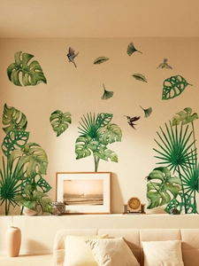 Detail of tropical monstera leaves and birds wall stickers in a cozy living room layout