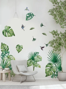 Detail of tropical green leaf and bird wall decals in a modern Nordic living room setting