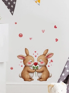 Détail d'un sticker mural de deux lapins tenant une rose rouge sur un mur blanc de salon