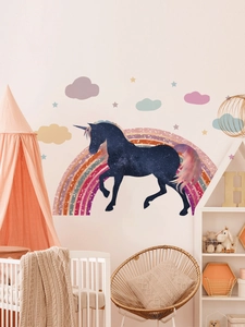 Detailed view of unicorn and rainbow wall decals in a warm pink nursery bedroom