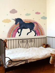 Detailed view of unicorn and rainbow wall decals in a cozy kids bedroom setting