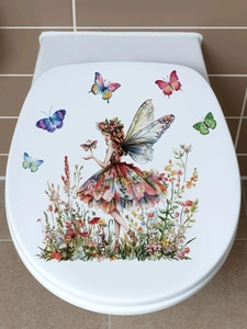 Detailed watercolor fairy and butterfly sticker applied on a bathroom toilet lid