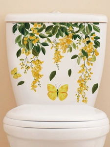 Detail of yellow flower vine and butterfly decals on a white ceramic toilet tank