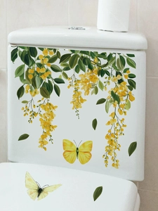 Detail view of yellow wisteria flowers and butterfly stickers on a white ceramic toilet
