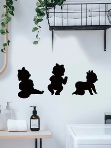 Detailed view of three black baby silhouette wall stickers in a modern nursery setting