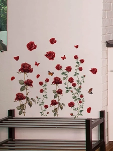 Detail of red rose wall stickers and colorful butterflies on a white living room wall